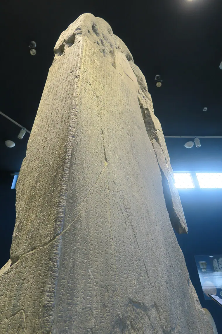 Vertical view of the Kül Tigin inscription displayed in a museum hall.